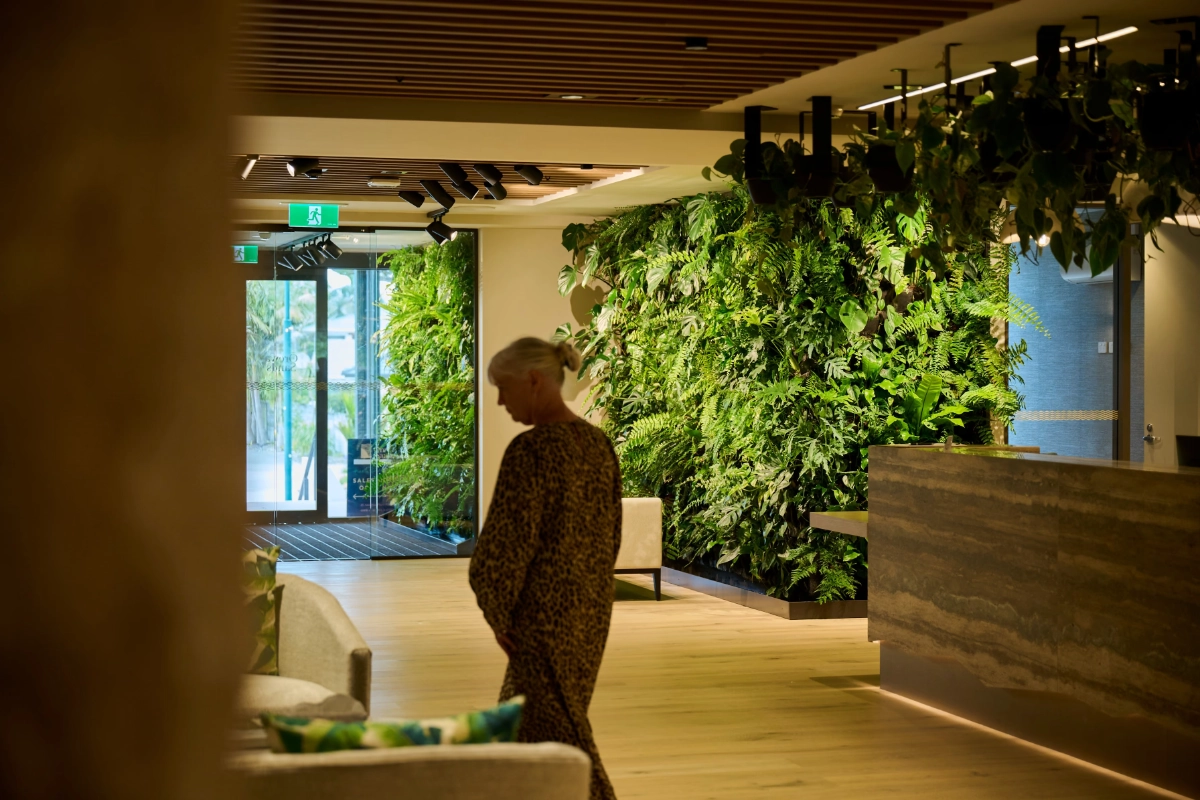 A resident passes a living wall on the way to the Orewa Sands reception