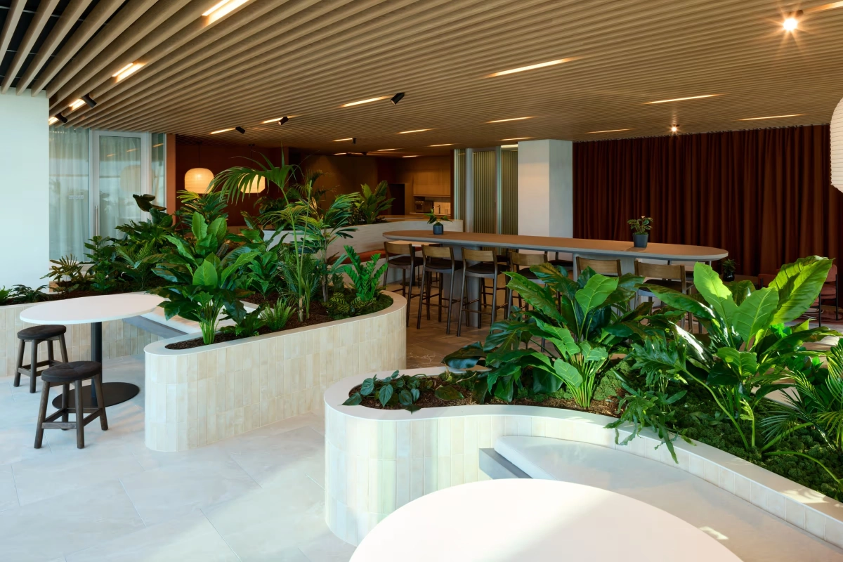 Curved tiled planters of tropical foliage around the SecuritEase cafe tables