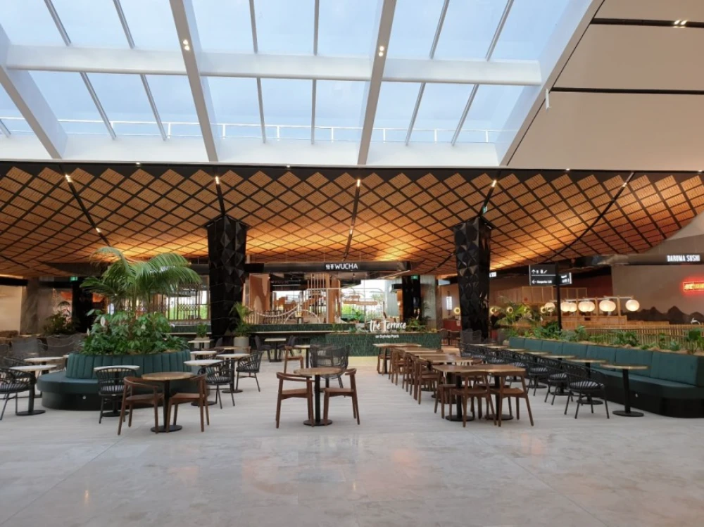 Food court dining area with planted feature beneath a timber lattice ceiling at Sylvia Park
