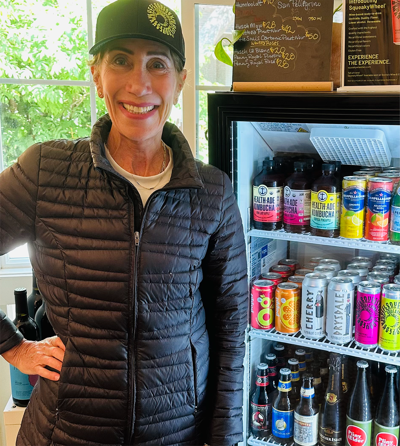 Woman smiling at camera in a SqueakyWheel hat