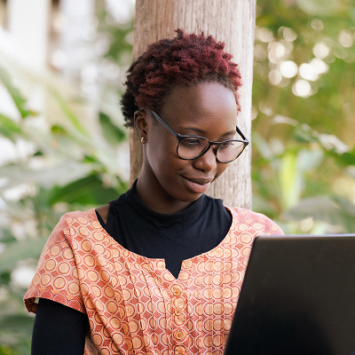 Female African worker, wearing glasses, working on her laptop