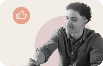 Smiling man with curly hair reaching forward with extended arm, with thumbs-up icon above