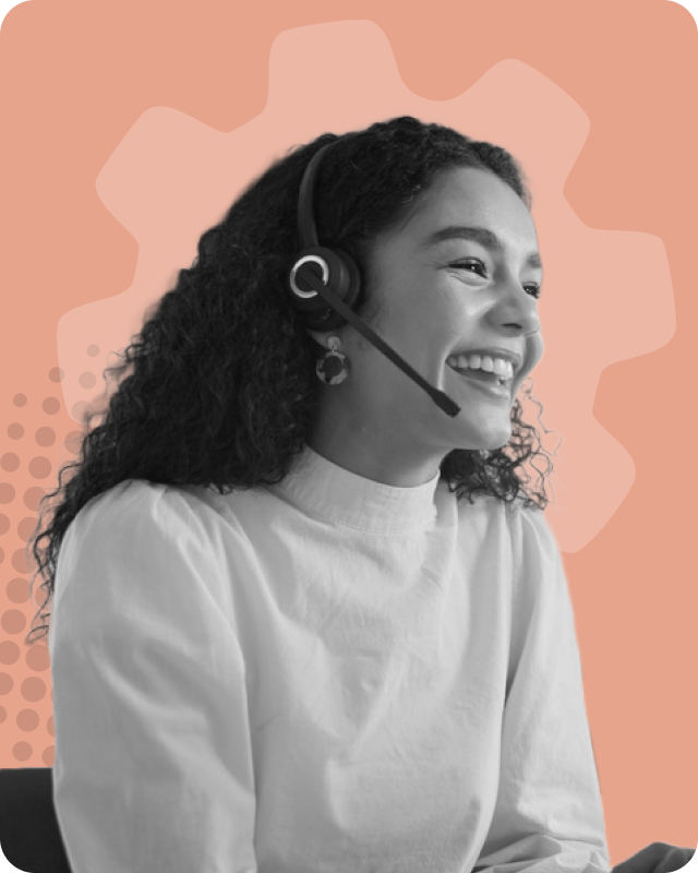 Smiling woman with curly hair wearing a headset and light-colored top, seated against a peach background with graphic gear and dot patterns.