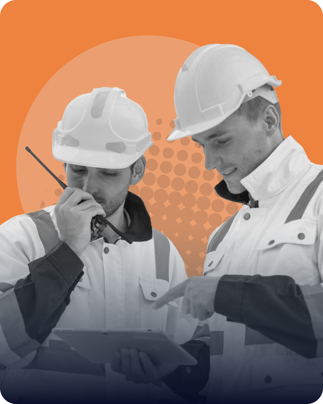 Two construction engineers wearing safety helmets and jackets, one speaking into a walkie-talkie and the other pointing at a tablet they both are looking at, with an orange graphic background.