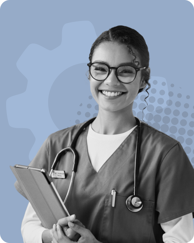 Smiling female healthcare professional wearing glasses and scrubs with a stethoscope around her neck holding a tablet.