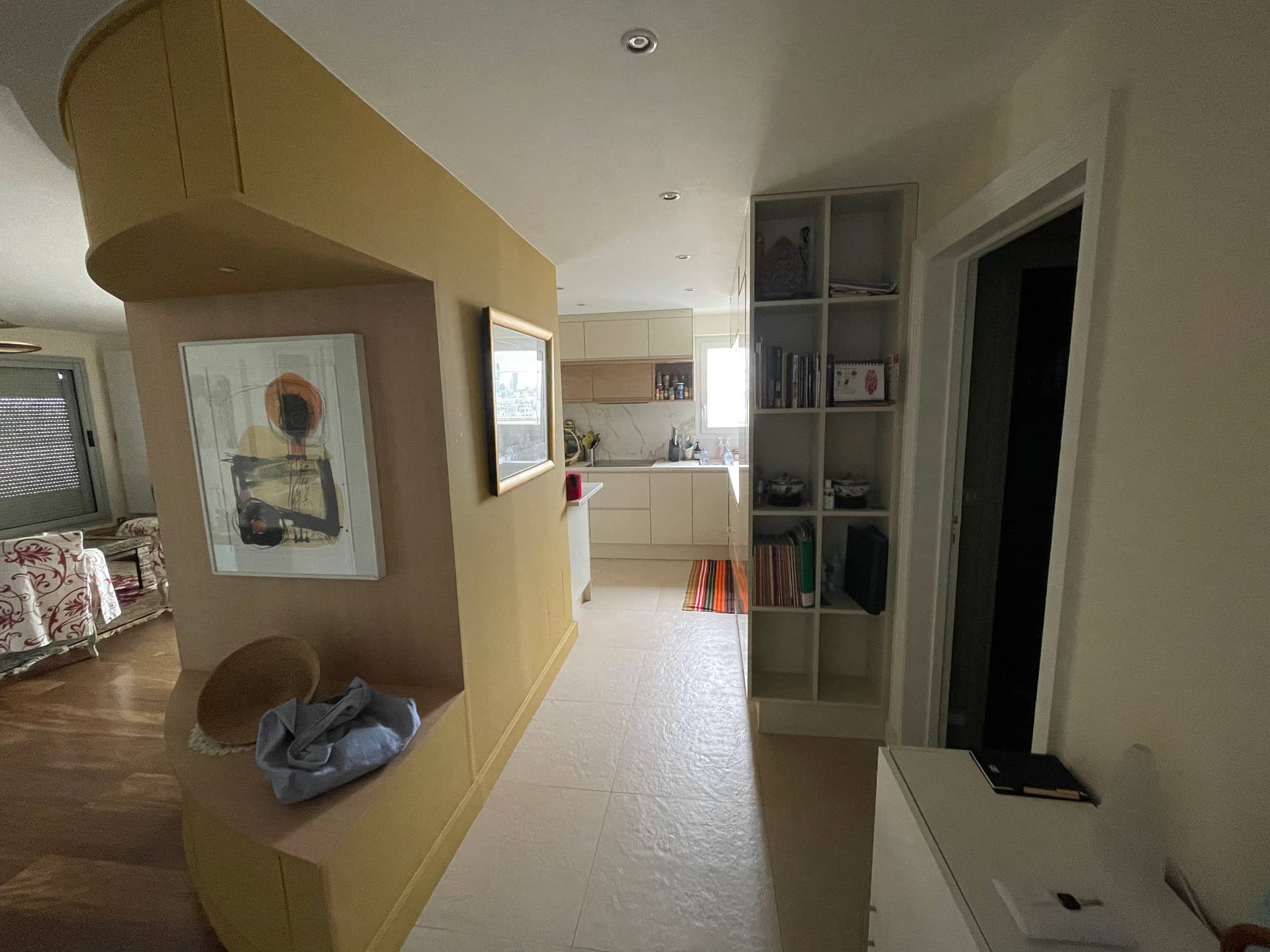 "Intérieur design avec éléments courbés jaunes vifs, éclairage intégré, et œuvre d'art moderne, illustrant l'expertise en design d'intérieur de MESURES & DEMESURE."