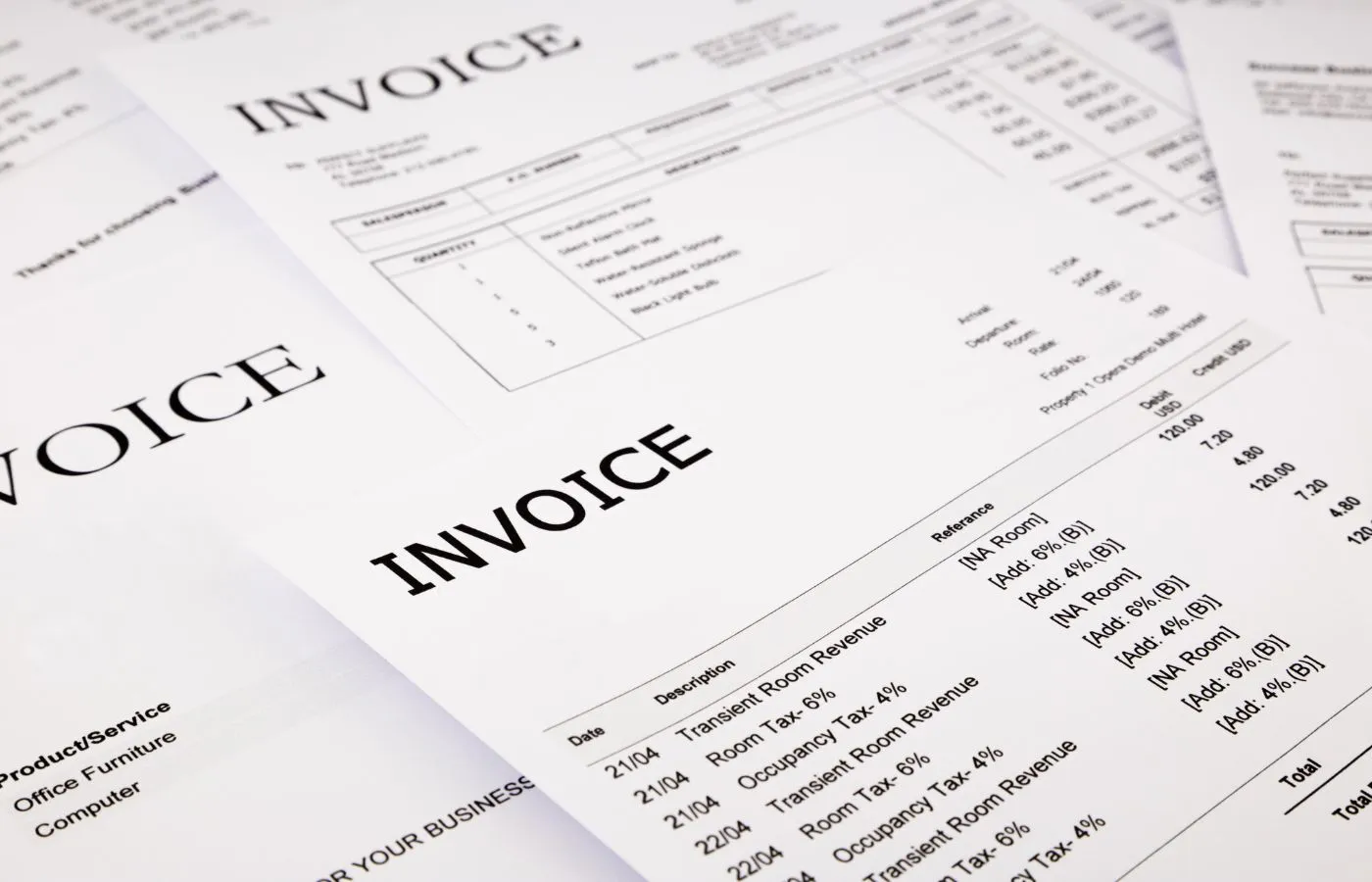 A stack of invoices waiting for OCR processing sits on a desk