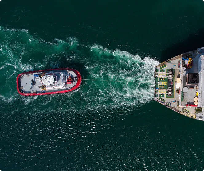 A big ship towing a smaller vessel in the water