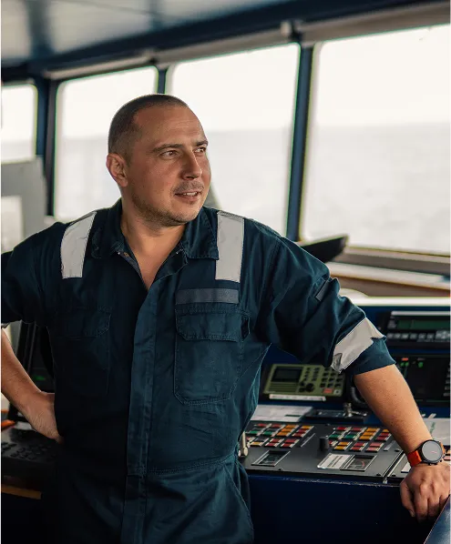 Person in a ship cabin looking at the water