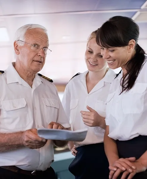 A elderly captain explaining something to the crew members