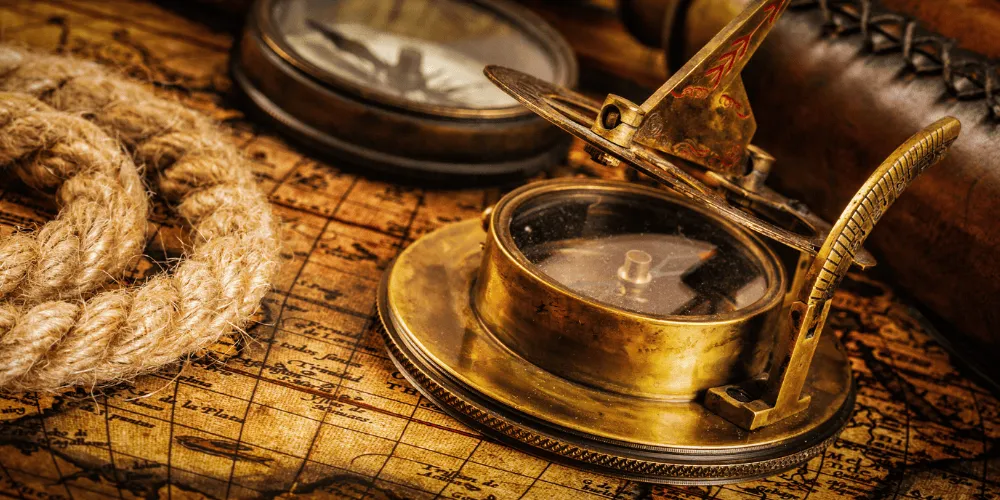 Compass and rope on top of vintage map