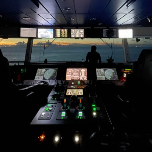 Bridge of a ship with radar and control panels lit up