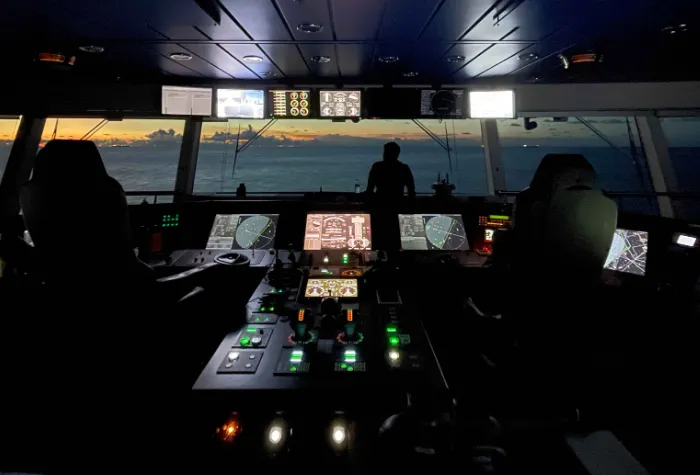 Bridge of a ship with radar and control panels lit up