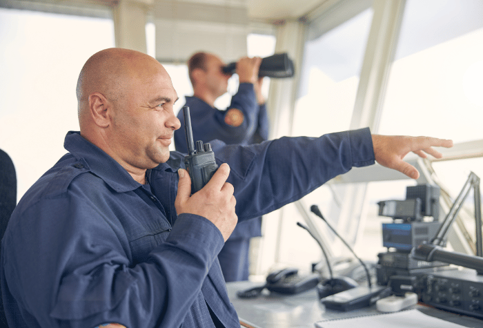 Man talking into radio on bridge of a ship