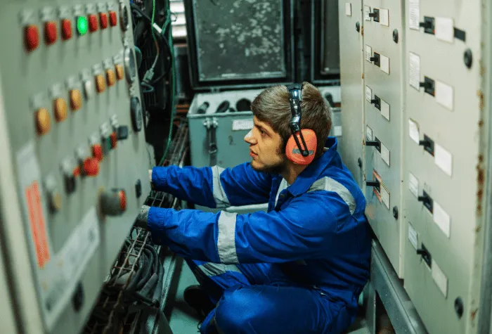 Marine engineer inspecting a ship switchboard