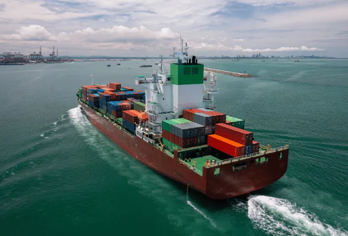 Cargo ship pulling into a harbor from sea