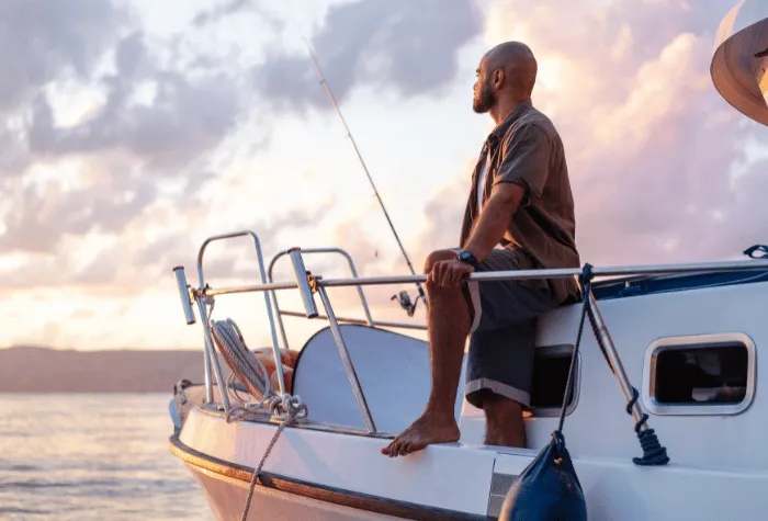 Young fishing boat captain looking out over the water on the port side of his boat