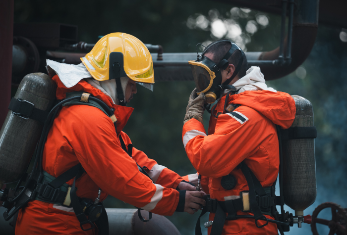 Two fire fighters putting on gear