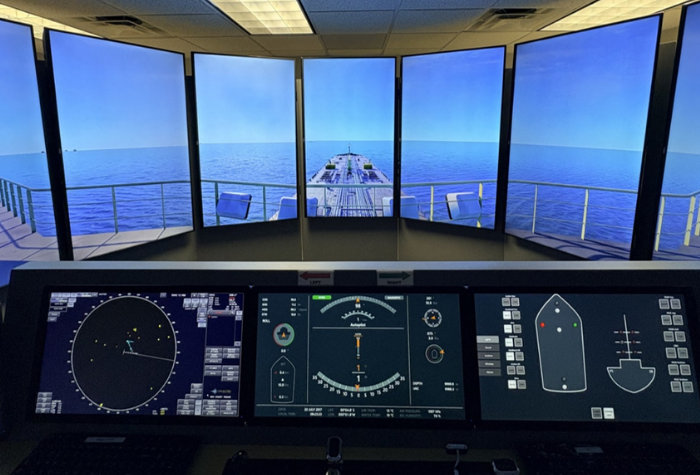 Full mission-bridge simulator with screens showing deck of a ship and ocean
