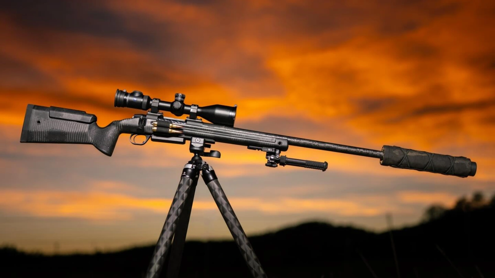 custom precision rifle on tripod at sunset