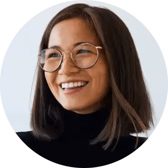 A woman with glasses smiling for a picture.