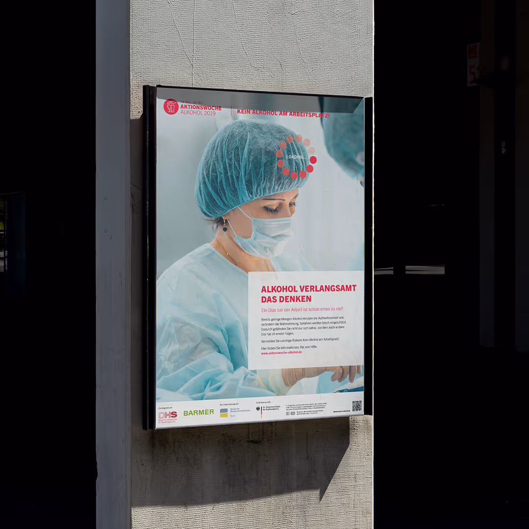 Deutsches Aufklärungsplakat von der „Aktionswoche Alkohol 2019“, auf dem eine Chirurgin in Handschuhen und Maske mit der Überschrift „Alkohol verlangsamt das Denken“ zu sehen ist und betont, dass Alkohol am Arbeitsplatz ein Problem ist