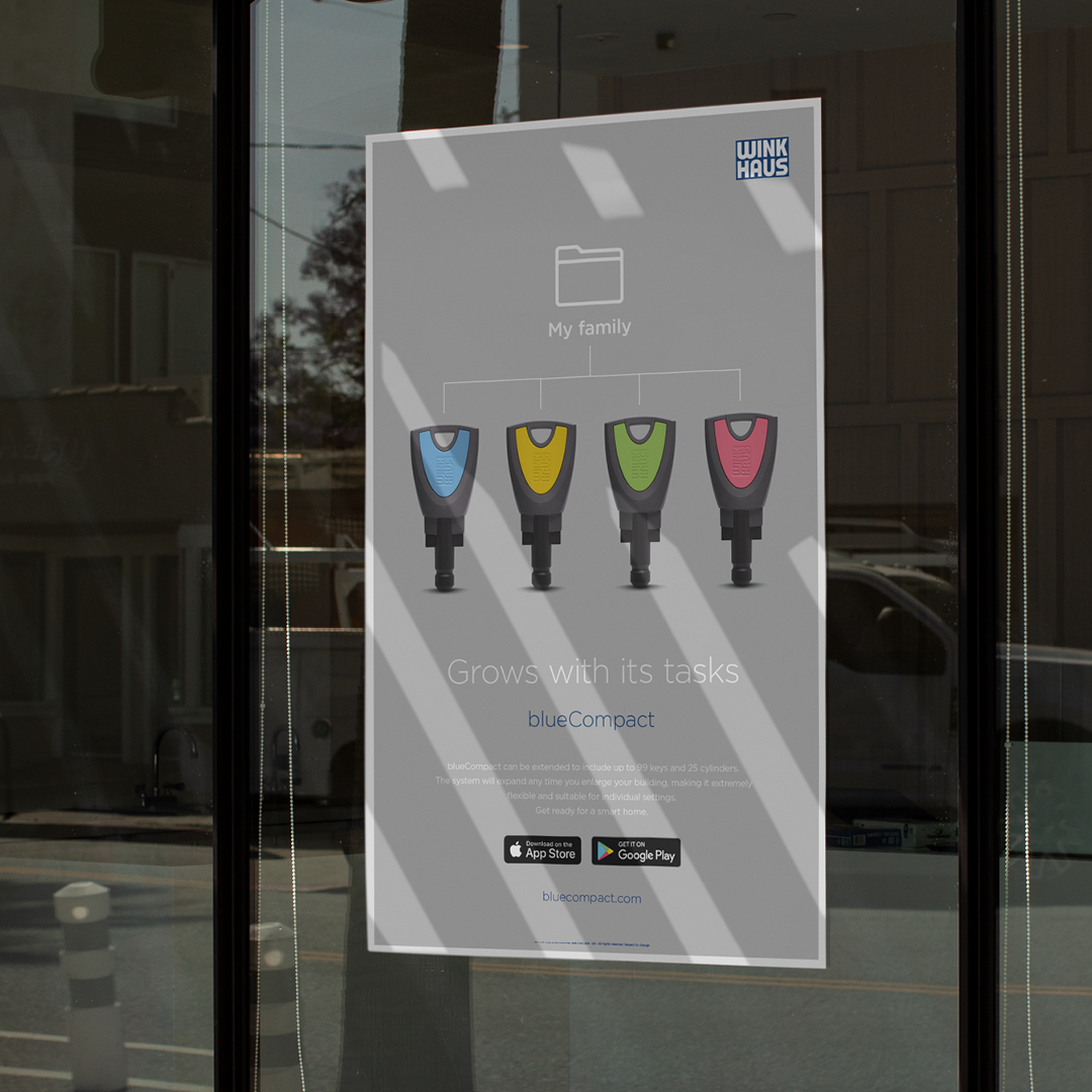 Ein graues blueCompact-Poster, das an einem Fenster hängt