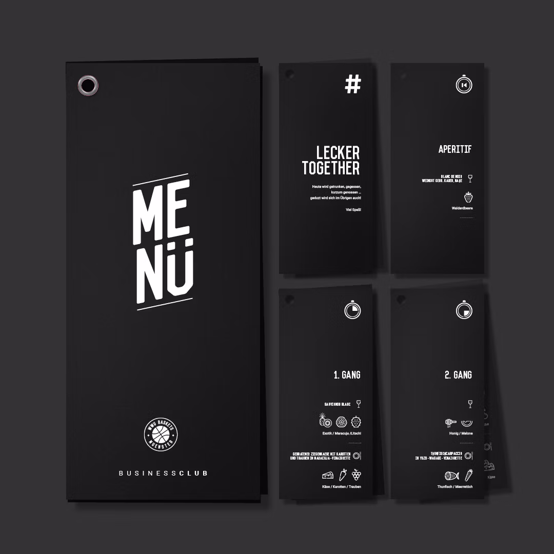 Schwarzes Menü mit weißer Aufschrift 'MENÜ' und Uni Baskets Logo. Daneben vier schwarze Karten mit weißen Texten zu Aperitif und Gängen.