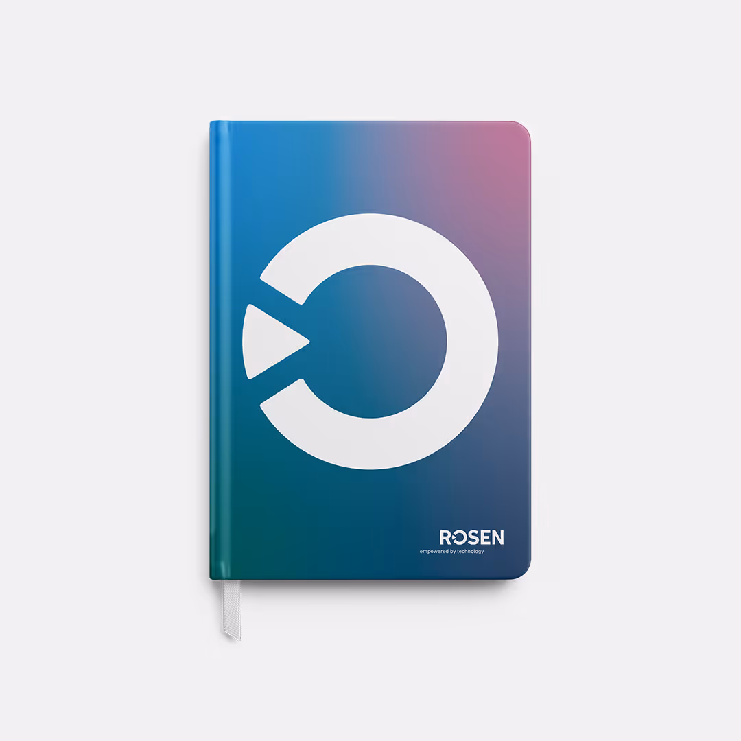 Geschlossenes Notizbuch mit einem blau bis violetten Farbverlauf, auf dem das weiße ROSEN-Logo und der Text ROSEN empowered by technology zu sehen sind.
