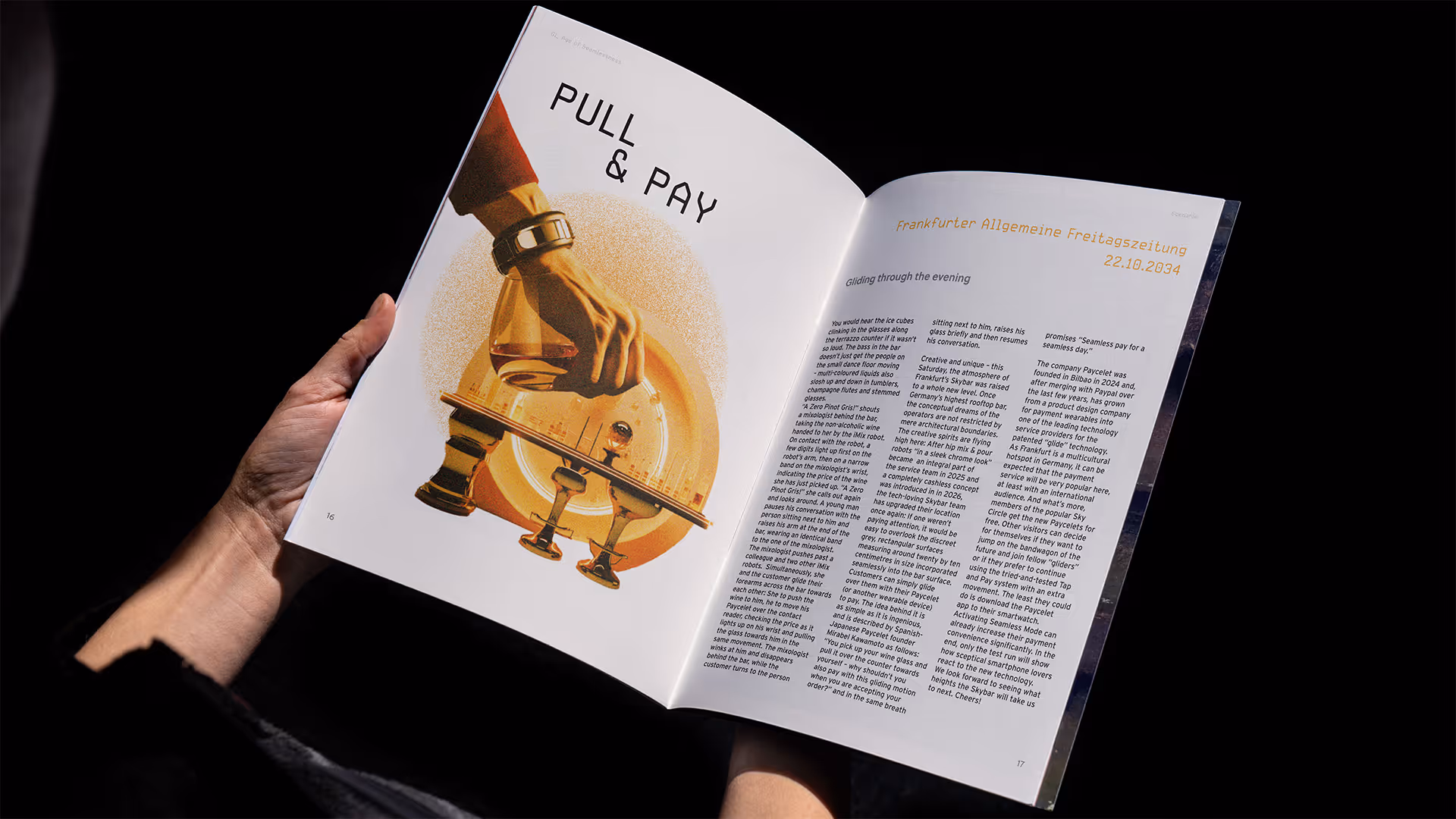 Person holding an open magazine showing an article titled 'PULL & PAY' with an illustration of a hand and bar tools on the left page.