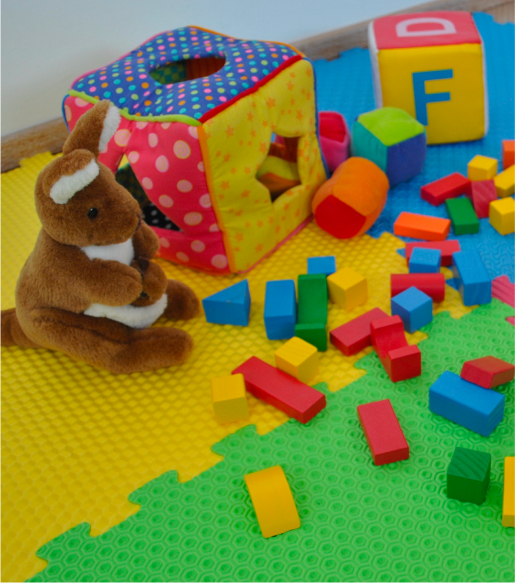 Spazio giochi per bambini in centro psicologico, con tappeto colorato, giocattoli educativi e peluche, pensato per supporto psicologico infantile.