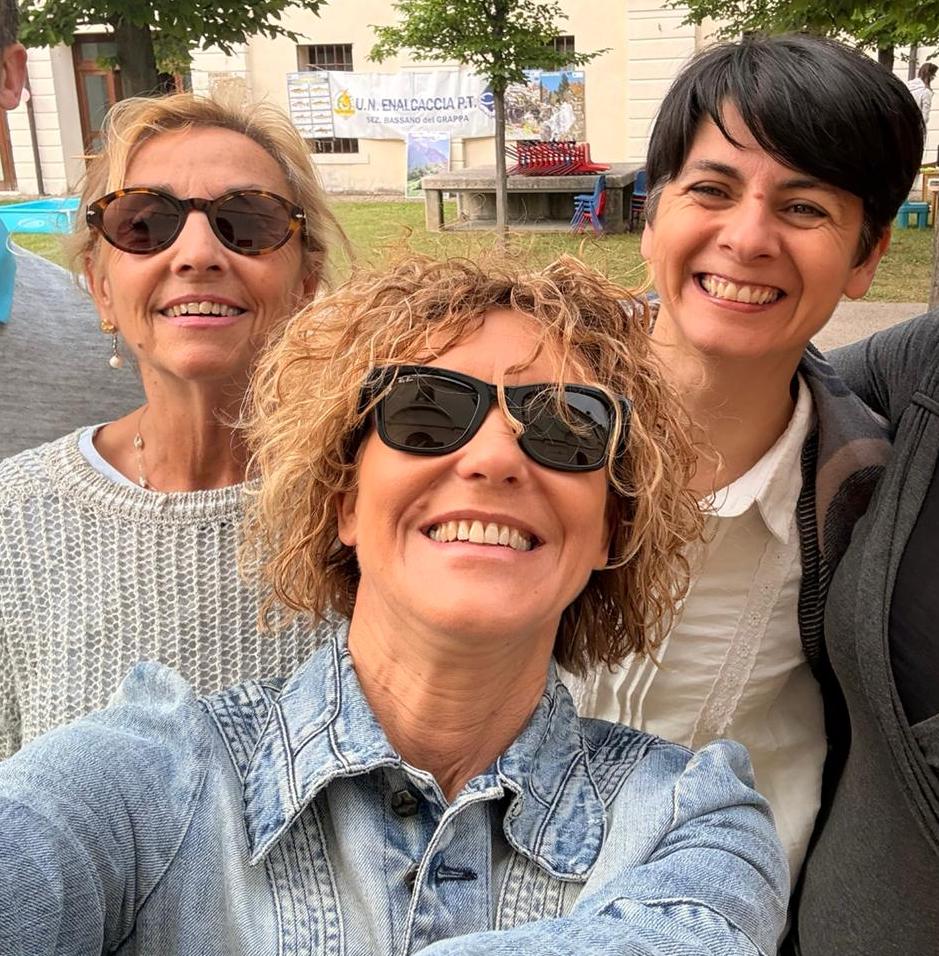 Team multidisciplinare in dialogo con famiglie e individui seduti attorno a un tavolo, in uno spazio caldo e professionale.