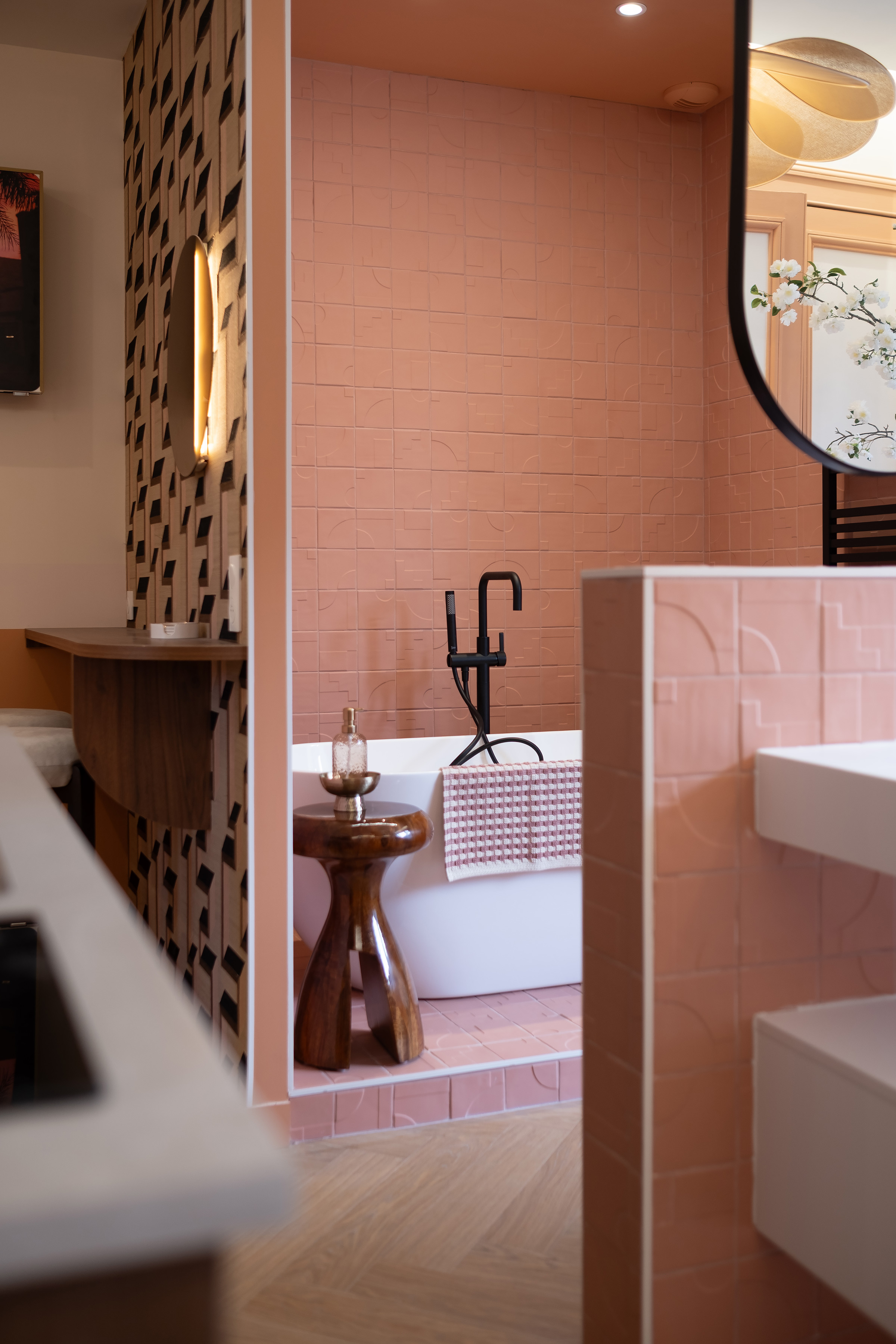 Salle de bain d'une chambre d'hôtes à Calais (Villa Lucia) : carrelage zellige rose terracotta, baignoire îlot blanche et robinetterie noire.