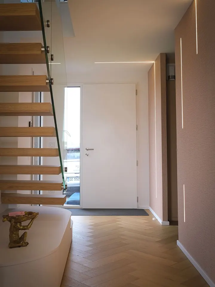 L'entrée de la maison à la livraison : escalier en chêne, parquet en point de Hongrie, murs enduits.