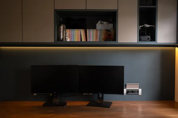 Bureau d'une maison à Ennevelin : menuiserie sur mesure gris anthracite à niches rétroéclairées et double écran sur plateau en noyer.