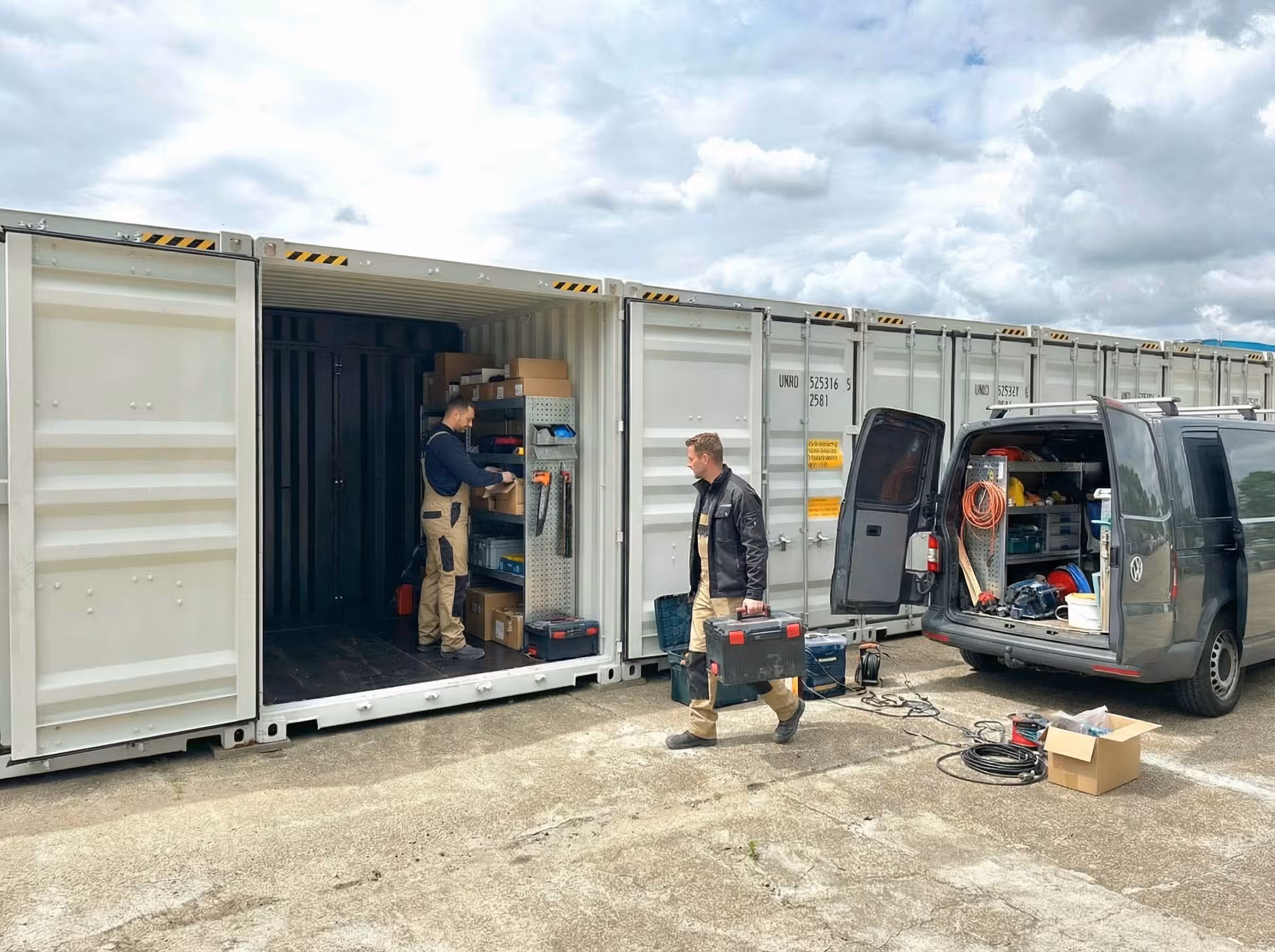 Zwei Männer einer Elektrofirma beladen Ihren Lagercontainer mit Werkzeug und Materialien