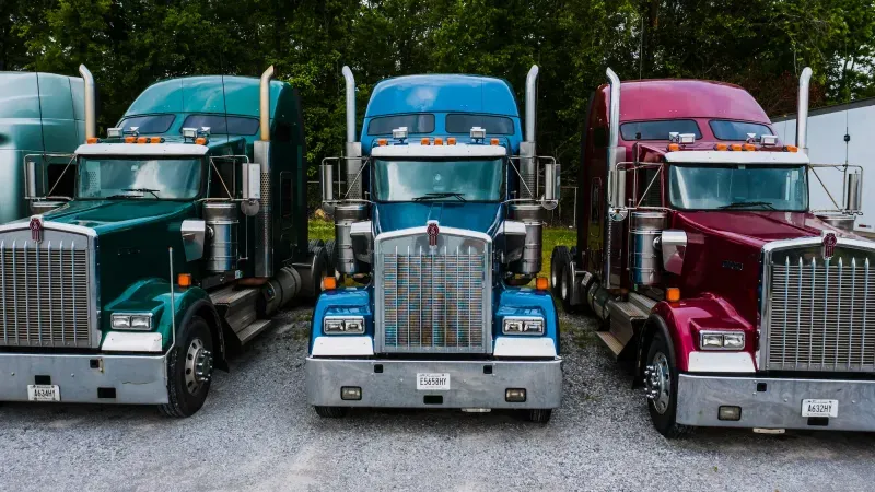 Row of heavy-duty tractor units parked on a lot