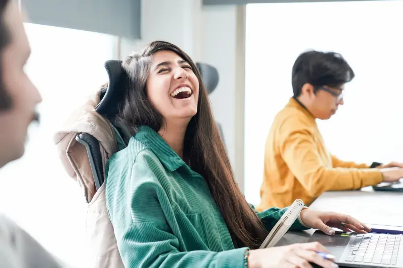Colleagues laughing together while working
