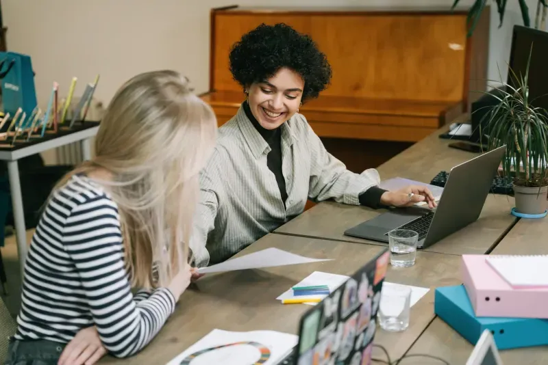 Two colleagues going through a workflow together at a desk