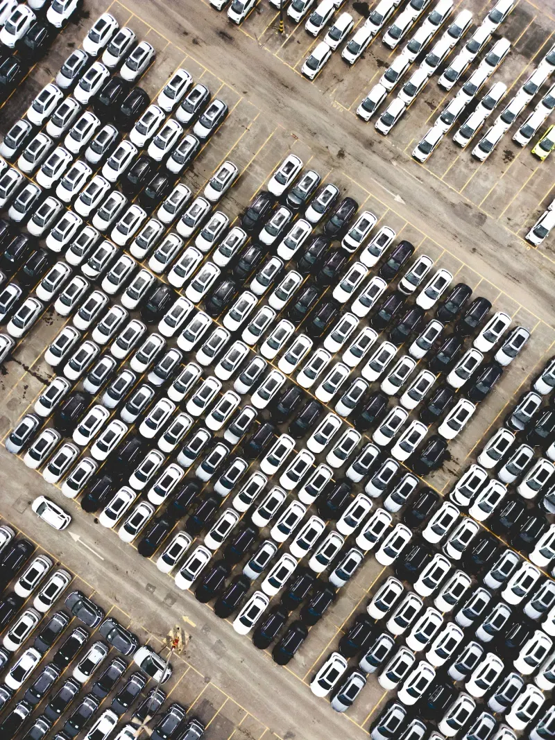Overhead view of new vehicles lined up across a distribution lot