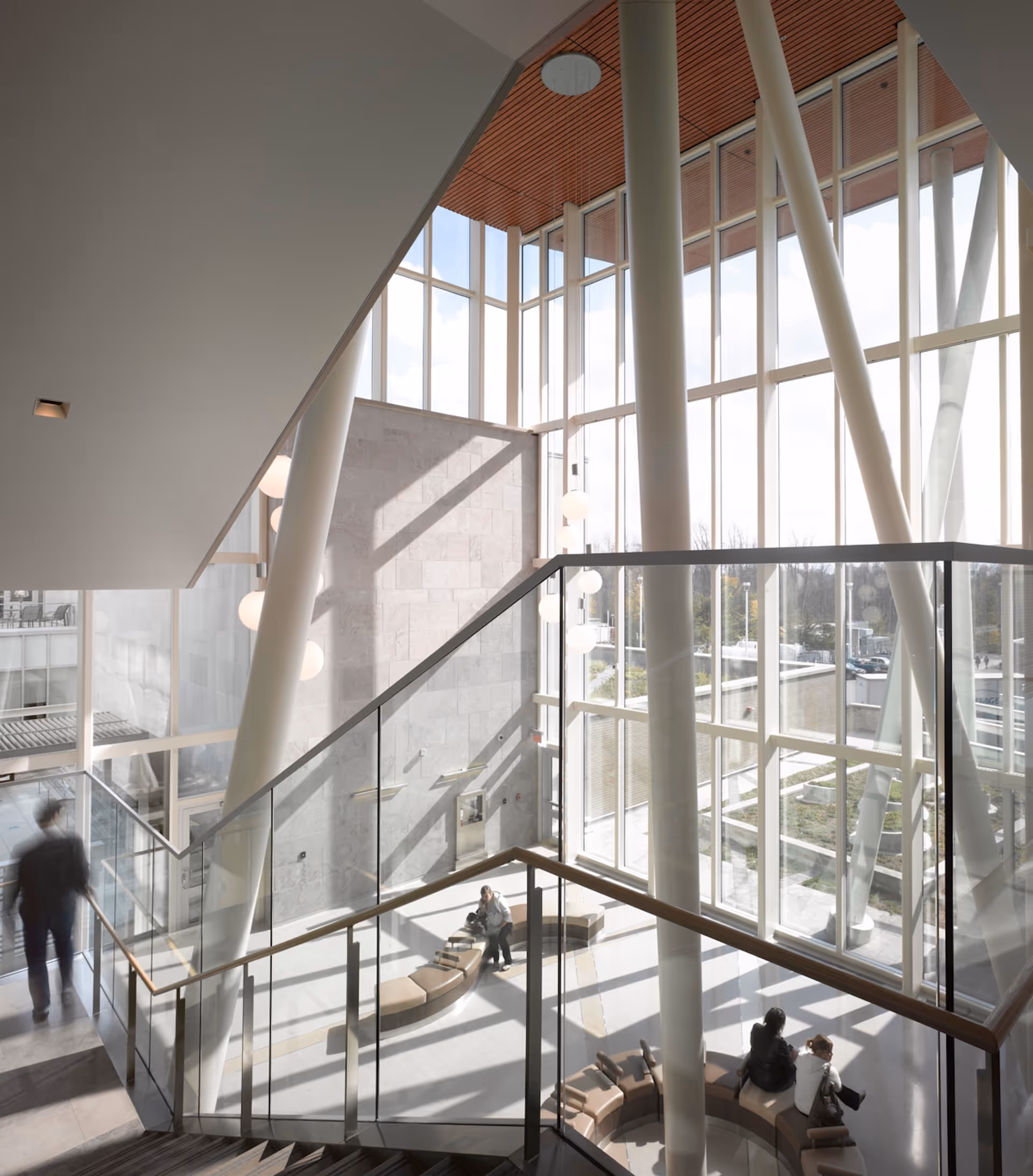 Atrium interior of a civic facility designed by Salter Pilon Architects, featuring angled white columns, glass railings, and abundant natural light.
