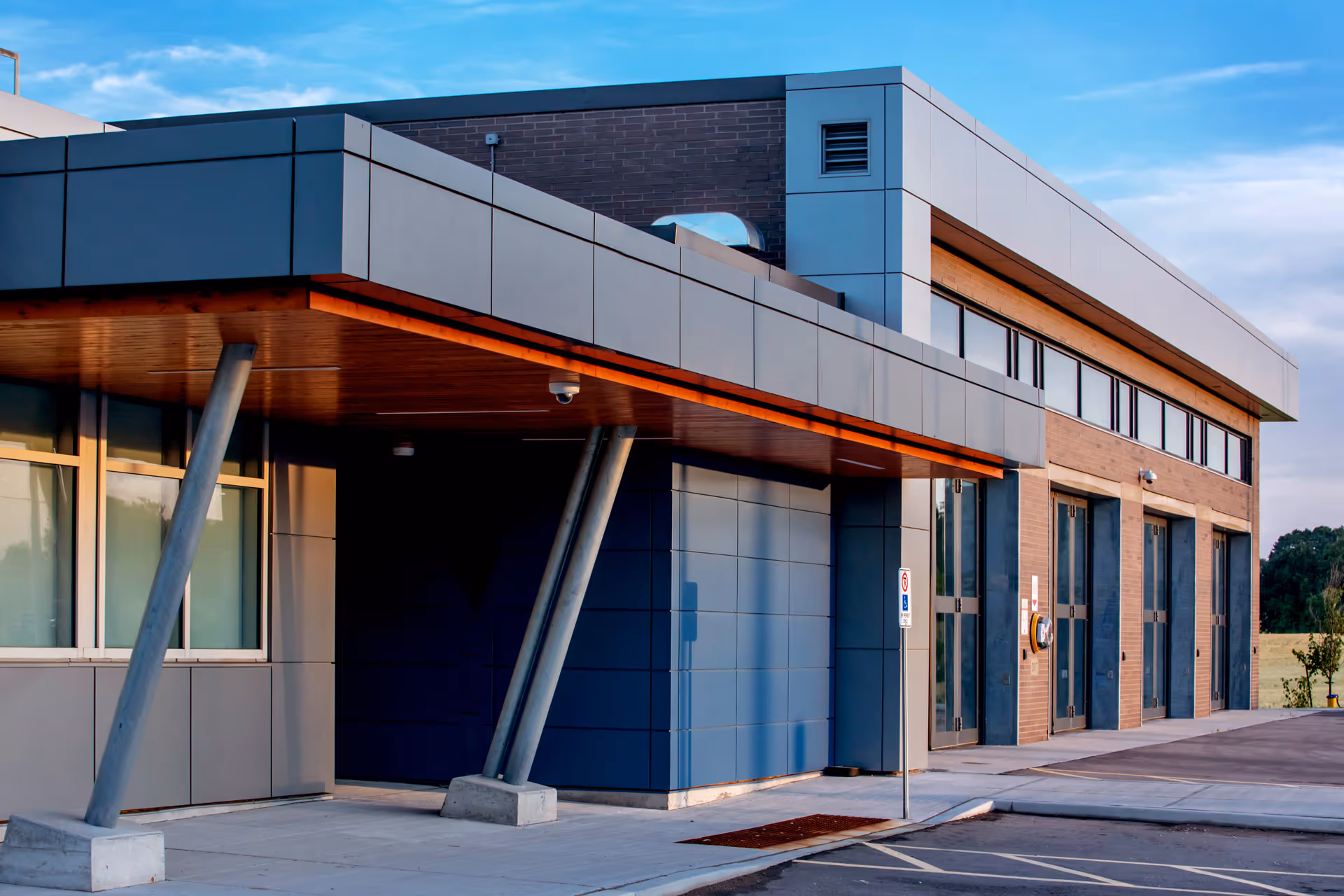 Exterior detail of York Paramedic Station showing angled steel column supports, metal cladding, and garage bay entrances.