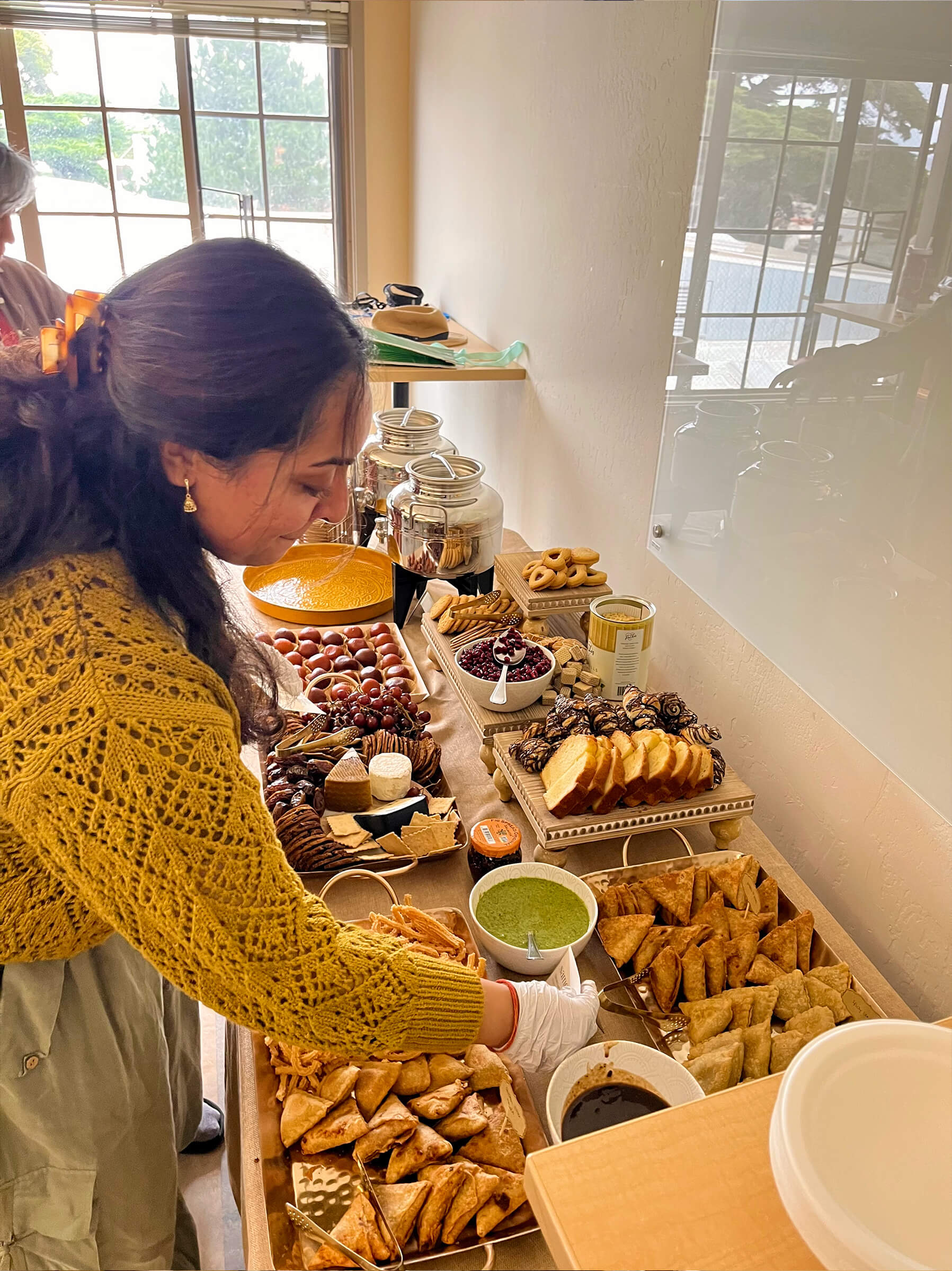 Caterer setting up a chai-cuterie spread for an event.