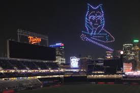 A vibrant drone light show forming intricate shapes in the night sky over a cityscape, showcasing advanced aerial choreography.