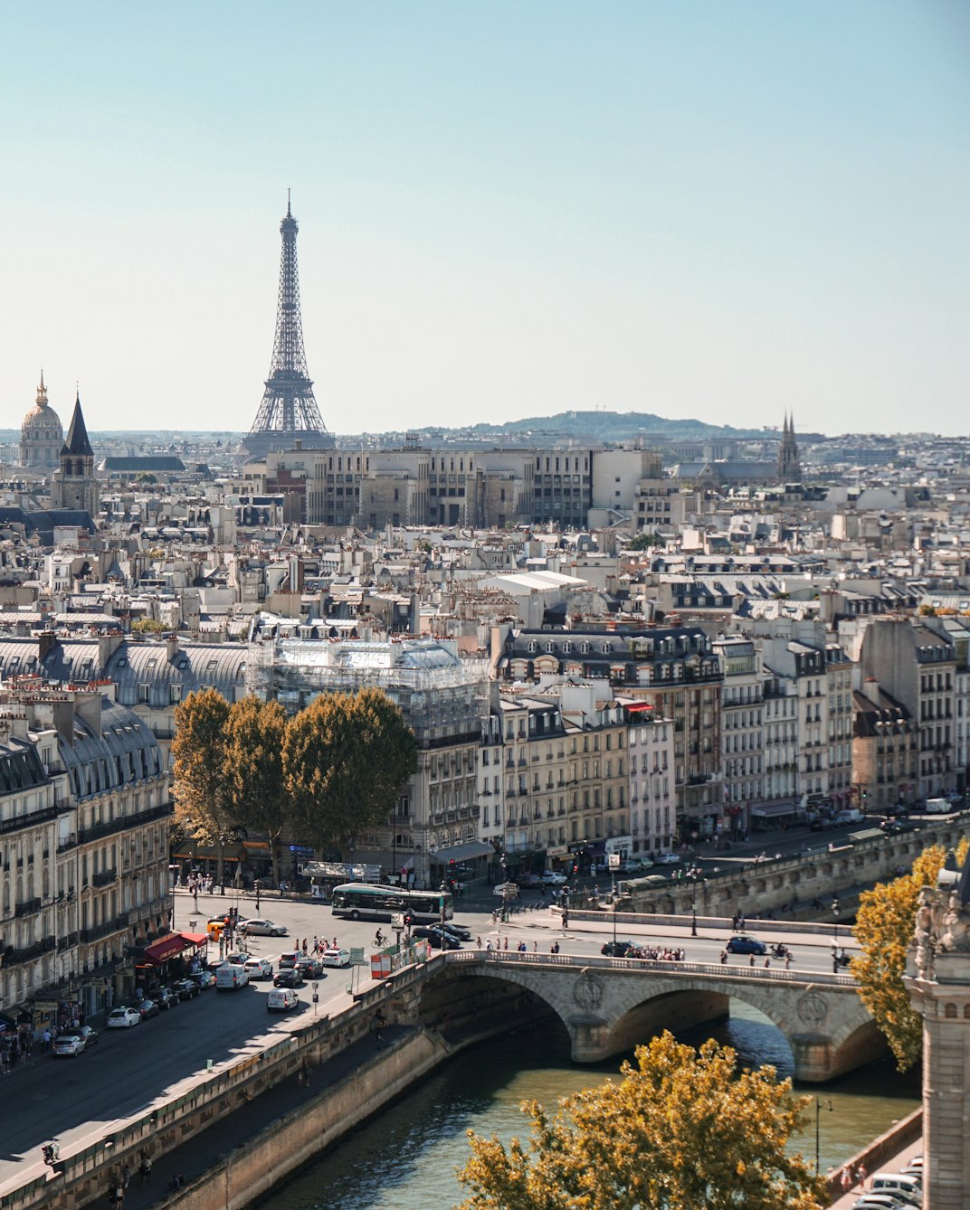 Paris rooftops with the Seine and the Eiffel Tower in the distance on a clear day.