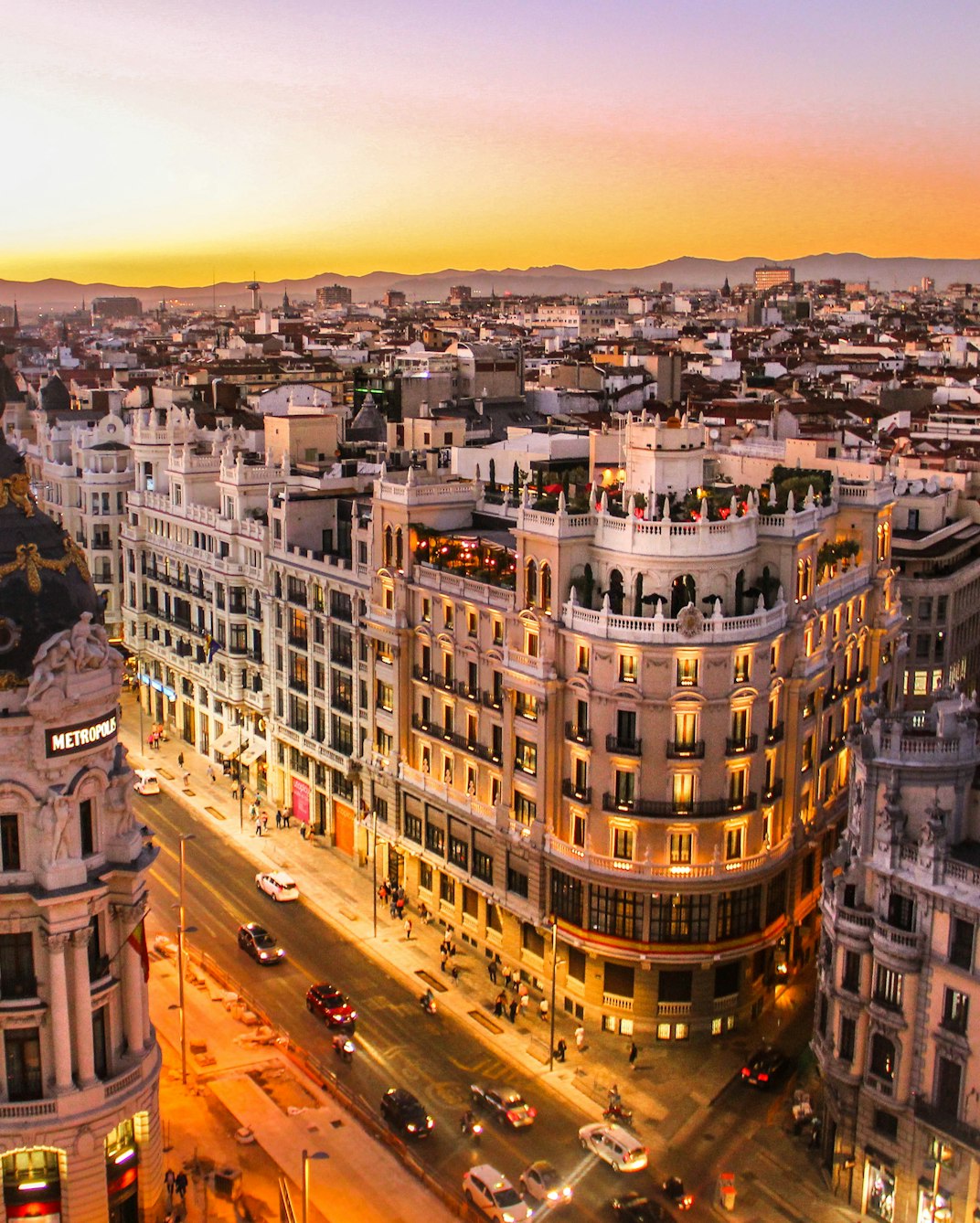 Ornate buildings along Gran Via in Madrid, with the city stretching out behind them at golden hour.