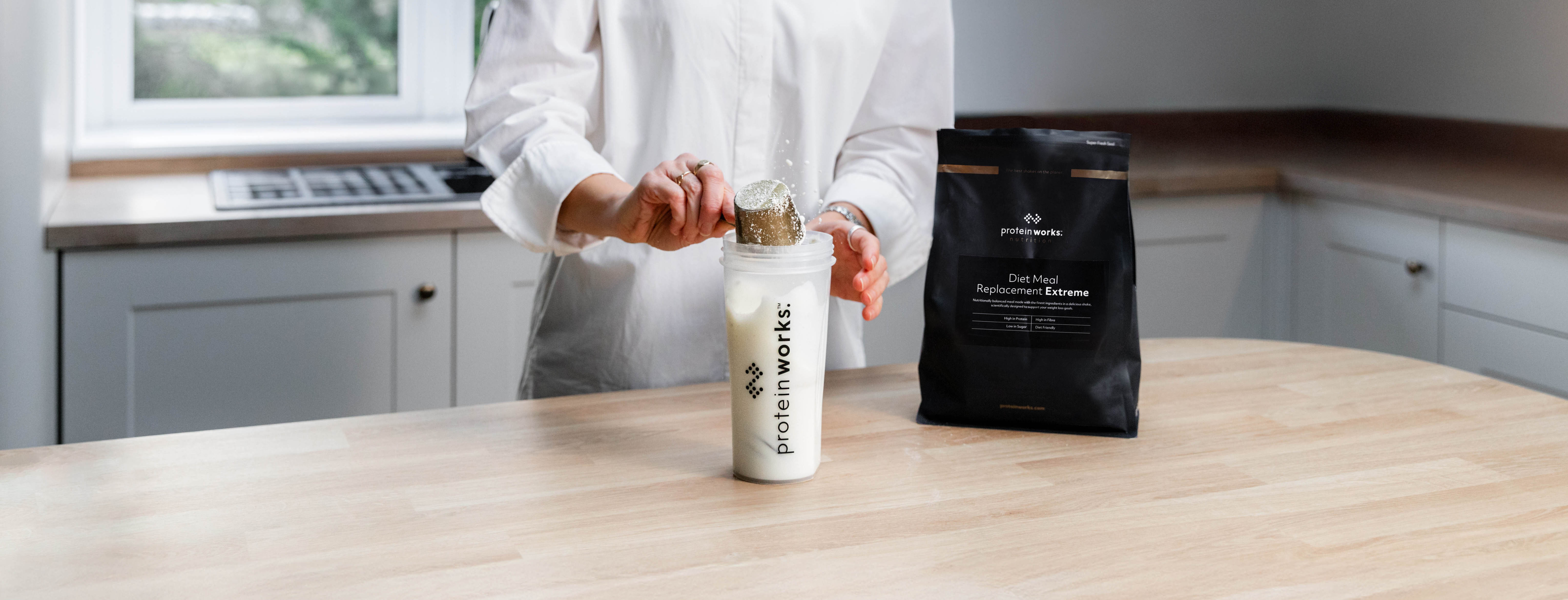 Protein Works products centred in clean, modern, well-lit kitchen. This is part of a promotional campaign.