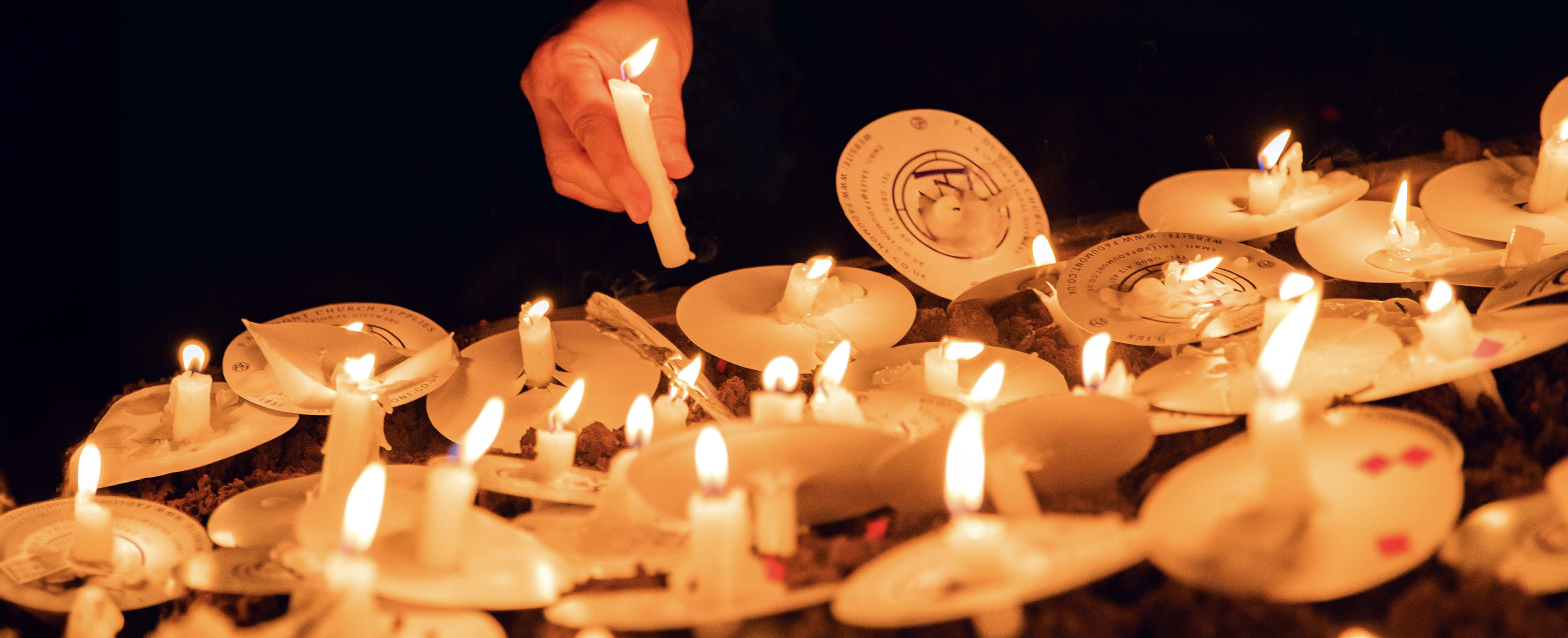 Manchester Pride candlelit vigil photo, close-up of candles being lit. 