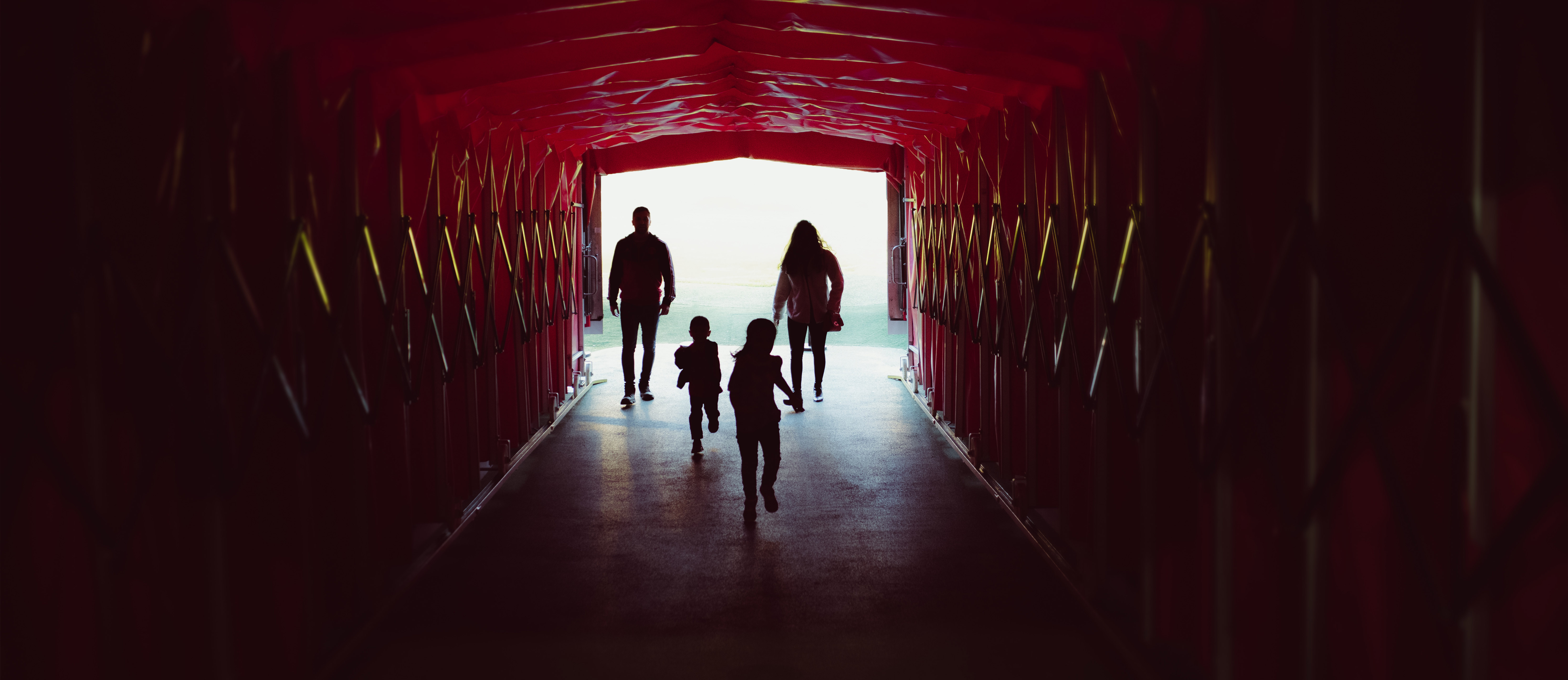 Still of family from Manchester United video shoot to promote their museum tour. They walk through 'The Players' Tunnel'.