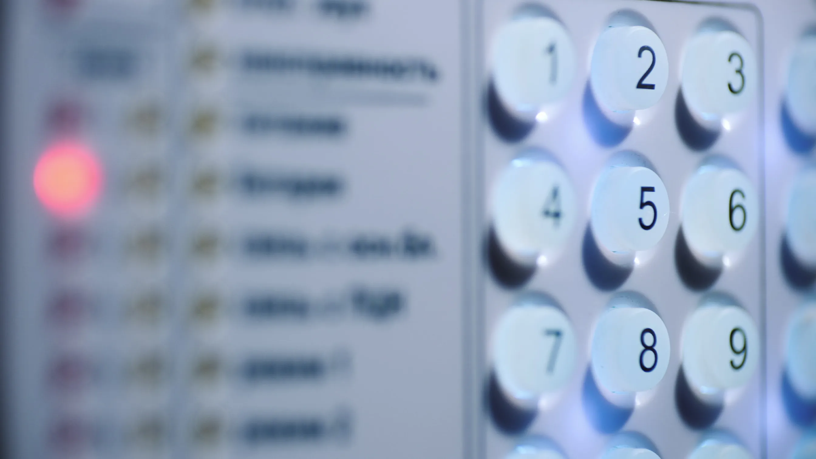 Close-up of a keypad with buttons numbered 1 to 9 on a security or alarm system panel.